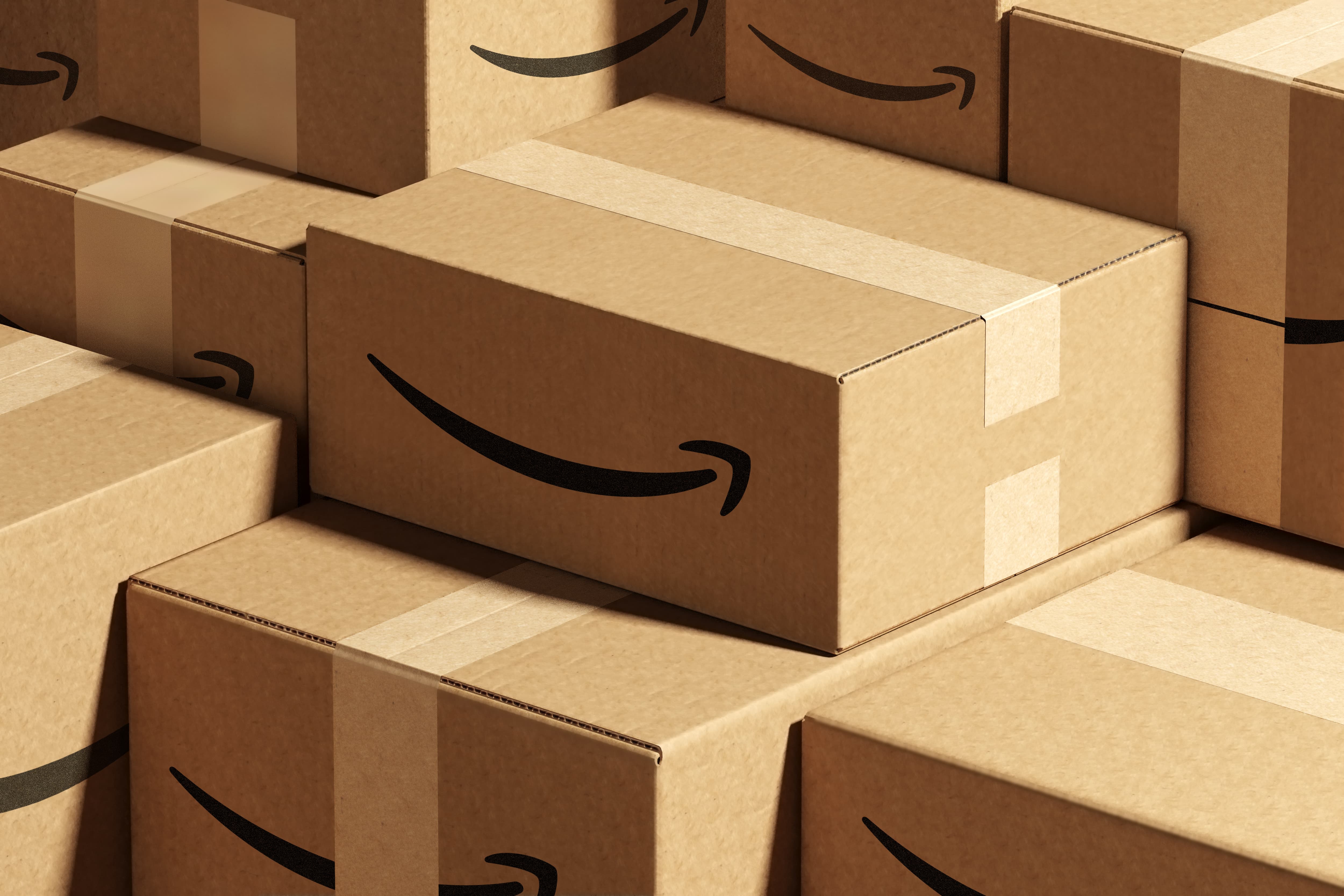 Amazon shipping boxes with a black curved smile-arrow printed on brown cardboard. The logo mark in this example has no lettering.